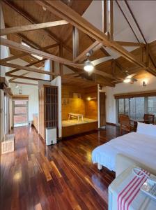 Una habitación grande con una cama grande y suelos de madera. en 鳳凰森之鳴, en Lugu