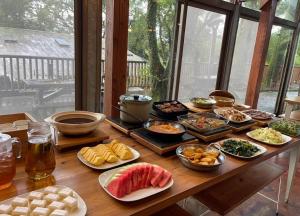 Una mesa con muchos platos de comida encima. en 鳳凰森之鳴, en Lugu