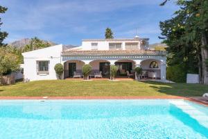 a house with a swimming pool in front of a house at Villa Los Tres Almendros in Marbella