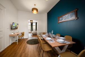 une salle à manger avec une table et un mur bleu dans l'établissement Majestic Square View Residence, à Prague