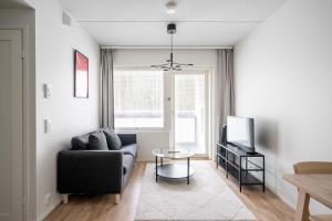a living room with a couch and a tv at Hiisi Homes Klaukkala in Klaukkala +13 photos