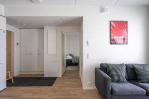 a living room with a couch and a bedroom at Hiisi Homes Klaukkala in Klaukkala