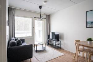 a living room with a couch and a table at Hiisi Homes Klaukkala in Klaukkala
