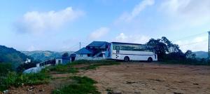 un autobus parcheggiato di fronte a una casa di Theeram holidays a Vagamon