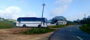 un autobus parcheggiato sul lato di una strada di Theeram holidays a Vagamon