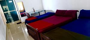 una camera con due letti con lenzuola rosse e blu di Theeram holidays a Vagamon