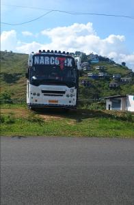 un autobus bianco parcheggiato sul ciglio della strada di Theeram holidays a Vagamon 1 altra foto