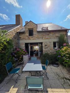 a patio with a table and chairs in front of a house at Maison en pierre accès 5 mn à pied plage in Arzon