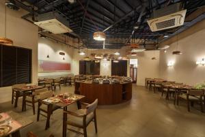 a restaurant with tables and chairs in a room at Kashe Benaras in Varanasi