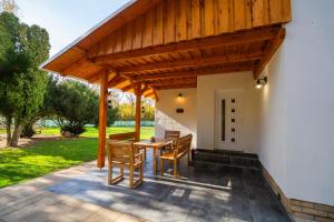 a wooden pavilion with a table and chairs on a patio at Non stop apartman 2 in Kaposvár +13 photos