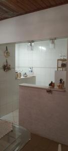 a kitchen with a counter and a refrigerator at FERIADÃO Suítes na montanha in Águas de Lindóia