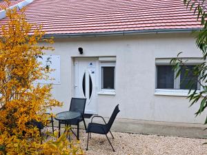 a house with chairs and a table in front of it at NassaFlat Apartman in Pécs