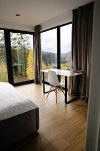 a bedroom with a bed and a table and a window at Лісогори in Slavske