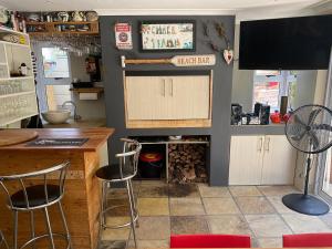 a kitchen with a bar with stools and a tv at Lovely Family Home in Durbanville in Durbanville