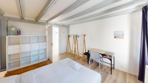 ein Schlafzimmer mit einem weißen Bett und einem Schreibtisch in der Unterkunft Bright & Modern 1-Bed Apt- Next to Public Transport RN18-2 in Prilly