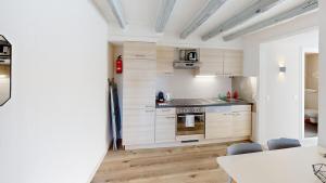 eine Küche mit Holzschränken und einem Tisch und Stühlen in der Unterkunft Bright & Modern 1-Bed Apt- Next to Public Transport RN18-2 in Prilly
