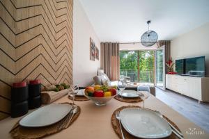 a dining room with a table with a bowl of fruit on it at Apartamenty Good Time - Stone Hill IV in Szklarska Poręba