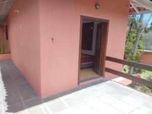 a entrance to a house with a pink wall at Quarto na mansão ilhabela in Ilhabela +5 photos