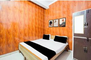 een slaapkamer met een bed met een houten muur bij Hotel pushpanjali in Haldwani