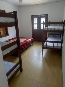 a room with two bunk beds and a bed at Quarto na mansão ilhabela in Ilhabela