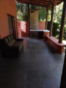 a living room with a couch and a table on a patio at Quarto na mansão ilhabela in Ilhabela