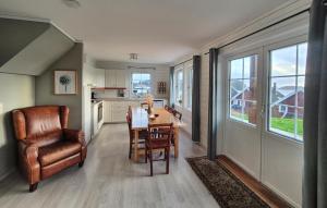 a kitchen and dining room with a table and a chair at Beautiful Home In Bøvågen With Sauna in Otterholmen