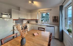 a kitchen with a wooden table with a vase on it at Beautiful Home In Bøvågen With Sauna in Otterholmen