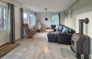 a living room with a couch and a stove at Beautiful Home In Bøvågen With Sauna in Otterholmen