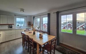 a kitchen with a wooden table and some windows at Beautiful Home In Bøvågen With Sauna in Otterholmen