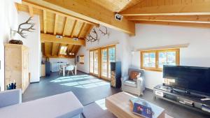 a living room with a large television and a table at Abitaziun Allegra Sur DG - Zuoz in Zuoz