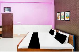 a bedroom with a large bed in a pink room at Hotel pushpanjali in Haldwāni