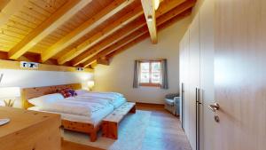 a bedroom with a large bed and a wooden ceiling at Abitaziun Allegra Sur DG - Zuoz in Zuoz