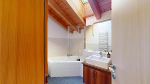 a bathroom with a sink and a bath tub at Abitaziun Allegra Sur DG - Zuoz in Zuoz +34 photos