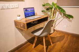 a laptop computer sitting on a desk with a chair at Cozy Two-Bedroom Apartment with Balcony in Islamabad
