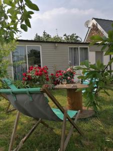 une table et une chaise devant une maison dans l'établissement L'HERMINE - pour 2 personnes, proche de la plage, à Binic