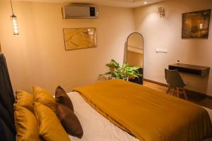 a bedroom with a bed with a yellow blanket at Cozy Two-Bedroom Apartment with Balcony in Islamabad +31 photos