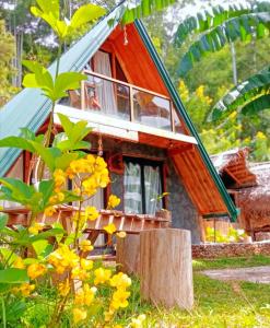 a small house in a forest with yellow flowers at Ella Shia Cabana in Badulla +36 photos