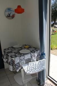 une table et des chaises dans une pièce avec une fenêtre dans l'établissement L'HERMINE - pour 2 personnes, proche de la plage, à Binic