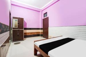 a bedroom with pink and white walls and a bed at Hotel pushpanjali in Haldwāni
