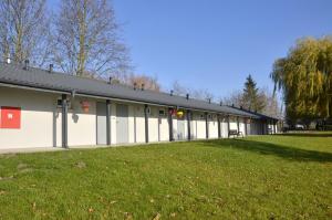 een groot gebouw met een grasveld ervoor bij Hotelik nad jeziorem w Łasinie in Łasin