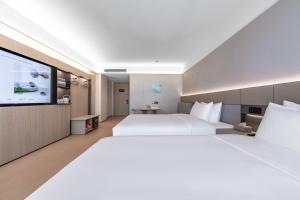 Ένα ή περισσότερα κρεβάτια σε δωμάτιο στο JI Hotel Shanghai Pudong International Airport Huinan +37 φωτογραφίες