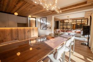 a dining room with a large wooden table with chairs at Antarès URSA 303 - luxury apartment ski inski out in Méribel