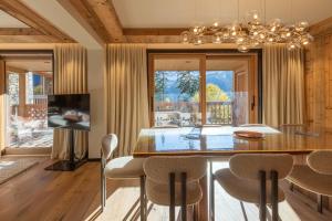 a dining room with a large wooden table and chairs at Antarès URSA 303 - luxury apartment ski inski out in Méribel