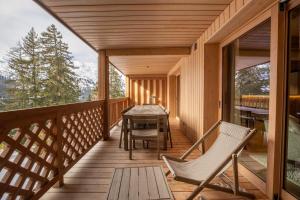 a balcony of a cabin with a table and chairs at Antarès URSA 303 - luxury apartment ski inski out in Méribel