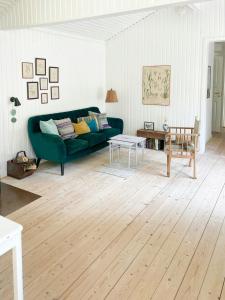a living room with a green couch and a table at Holiday Home By Nyrup Bay And Rørvig Harbour in Rørvig