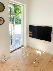 a living room with a flat screen tv on a wall at Holiday Home By Nyrup Bay And Rørvig Harbour in Rørvig +27 photos