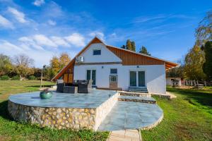 a small white house with a stone patio at Non stop apartman 2 in Kaposvár