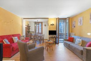 a living room with couches and a dining room at Appartamento Rifugio dei Sogni - Happy Rentals in Pragelato