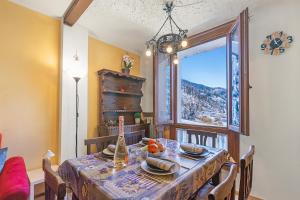 a dining room with a table and a window at Appartamento Rifugio dei Sogni - Happy Rentals in Pragelato