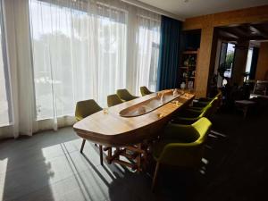 a conference room with a long wooden table and chairs at Fuxian Lake Lanshan Su Ant Nest Homestay in Xujiadu +62 photos